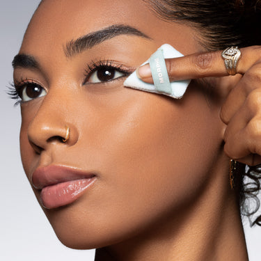 Model pressing a triangular blue MORPHE mini powder puff under the eye, from the To The Point Mini Powder Puff Trio.