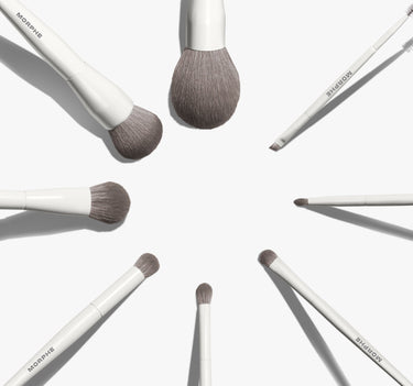 Morphe Best Of Blends 8 Piece Face Eye Brush Set with white handles and gray bristles arranged in a starburst circle, MORPHE printed on each handle.