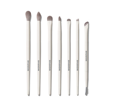 Eye Want It All 7 Piece Eye Brush Set featuring seven white-handled MORPHE brushes with gray bristles, ranging from large dome to angled liner and dual-ended spoolie. | Eye Want It All 7-Piece Eye Brush Set