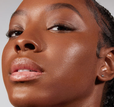 {Deep 30W} Model wearing Lightform Extended Hydration Foundation in shade Deep 30W, showcasing a luminous, hydrated finish on deep warm-toned skin.