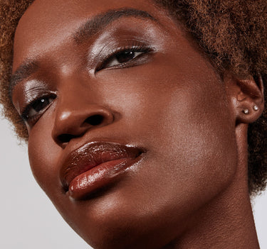 {Deep 35W} Model wearing Lightform Extended Hydration Foundation in Deep 35W with shimmery eyeshadow, glossy burgundy lip, and a luminous, dewy complexion.