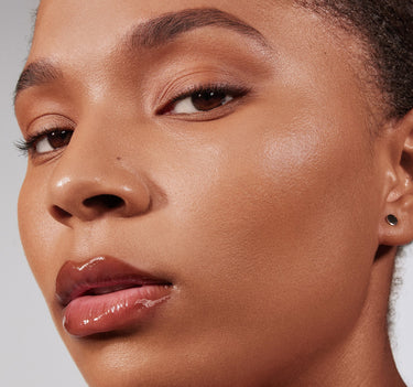 {Rich 23C} Model wearing Lightform Extended Hydration Foundation in shade Rich 23C, showcasing a dewy, luminous finish on medium-deep glowing skin.