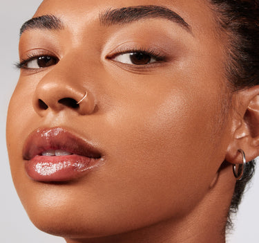 {Rich 25N} Model wearing Lightform Extended Hydration Foundation in shade Rich 25N, showing a dewy, luminous finish on warm medium-deep skin.