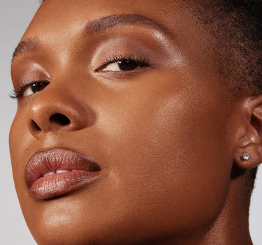 {Rich 26N} Close-up model shot wearing Lightform Extended Hydration Foundation on deep warm skin tone with a dewy, luminous, hydrated finish.