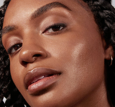 {Rich 27N} Close-up of model wearing Lightform Extended Hydration Foundation with a natural, luminous finish on deep-warm skin tone.