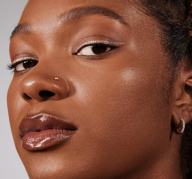 {Rich 28W} Close-up of Lightform Extended Hydration Foundation in Rich 28W worn on deep skin tone, showing a luminous, hydrated finish.
