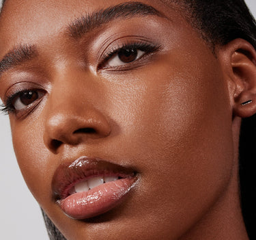 {Rich 29N} Close-up model shot showing Lightform Extended Hydration Foundation in shade Rich 29N with a dewy, luminous finish on deep skin.