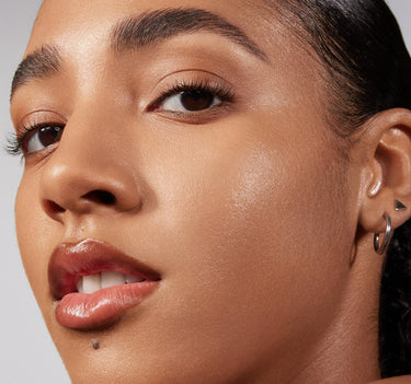 {Tan 22W} Closeup of model wearing Lightform Extended Hydration Foundation in Tan 22W, showing a luminous, dewy complexion with a natural skin-like finish.