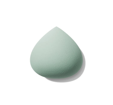 Sage green teardrop-shaped All Covered Shapable Makeup Sponge with fine porous texture on white background. | All Covered Shapable Makeup Sponge