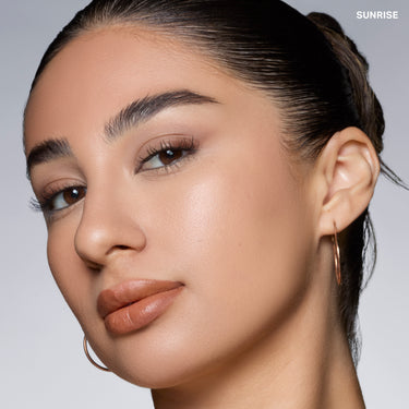 {Sunrise} Model wearing Cloudlight Soft Glow Veil in SUNRISE, showing luminous soft-glow finish on medium-tan skin.