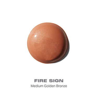 {Fire Sign} Hot Shot Sun Drops bronzer smear in FIRE SIGN, Medium Golden Bronze — shimmery golden-bronze dome-shaped swatch.