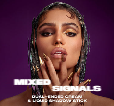 {Committed/Conflicted} Model wearing gold eyeshadow and burgundy liner with gold stiletto nails poses against purple background; text reads "MIXED SIGNALS DUAL-ENDED CREAM & LIQUID SHADOW STICK."