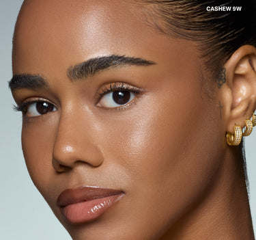 {Cashew 9w} Model close-up wearing Wakeup Artist Under Eye Correcting Concealer in CASHEW 9W, showing bright, smooth under-eye coverage on deep warm skin.