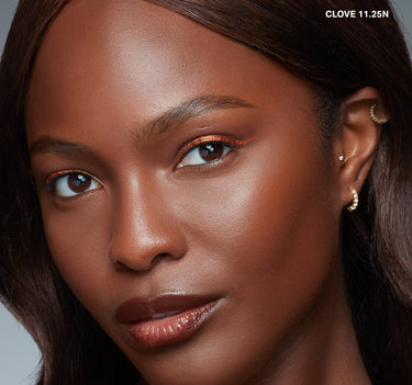 {Clove 11.25n} Model wearing Wakeup Artist Under Eye Correcting Concealer in shade CLOVE 11.25N, shown with seamless under-eye coverage on deep skin.
