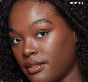 {Sienna 11.5c} Model wearing Wakeup Artist Under Eye Correcting Concealer in shade SIENNA 11.5C, shown on deep skin tone with brightened under-eye area.
