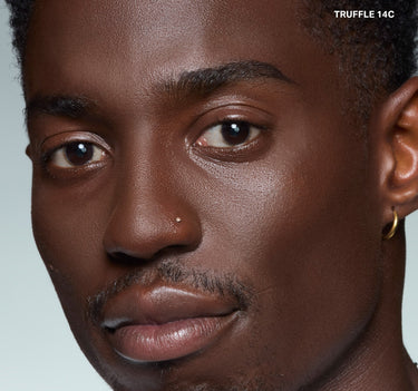 {Truffle 14c} Model wearing Wakeup Artist Under Eye Correcting Concealer in TRUFFLE 14C with seamless under-eye coverage on deep skin.