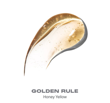 {Golden Rule} Swatch of Hot Honeys Plumping Lip Oil in GOLDEN RULE Honey Yellow shade, glossy honey-colored formula with shimmer particles.