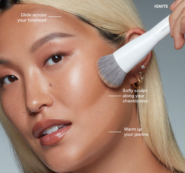 {Flicker} Sudden Heat Creamy Bronzer Stick shade IGNITE applied on model with brush and callouts: Glide across your forehead, Sofly sculpt along your cheekbones, Warm up your jawline.