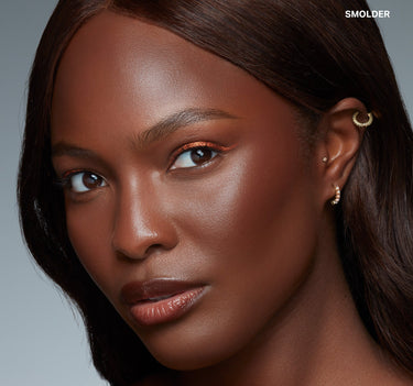 {Smolder} Model wearing Morphe Sudden Heat Creamy Bronzer Stick in shade Smolder, bronzed glowing skin with copper eye look, "SMOLDER" text overlay.