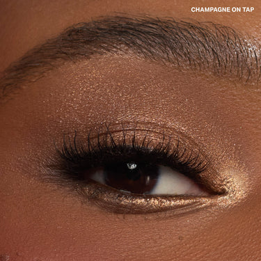 {Champagne On Tap} Dazzling Metallics Eyeshadow Trio close-up eye macro wearing warm champagne-bronze metallic shadow, labeled "CHAMPAGNE ON TAP."