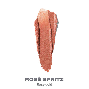 {Rose Spritz} Dreamlight Gelee Highlighter Stick shade swatch in rose gold with text "ROSÉ SPRITZ — Rose gold."